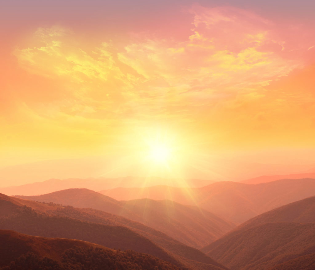 California sunrise over the mountains with colors of yellow, orange, pink, purple, dark green and brown